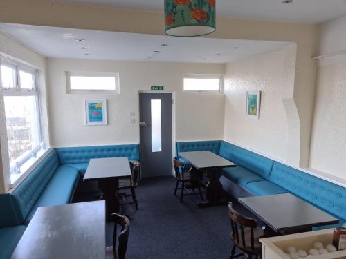 a dining room with blue booths and tables at The Trelinda Guest House in Newquay