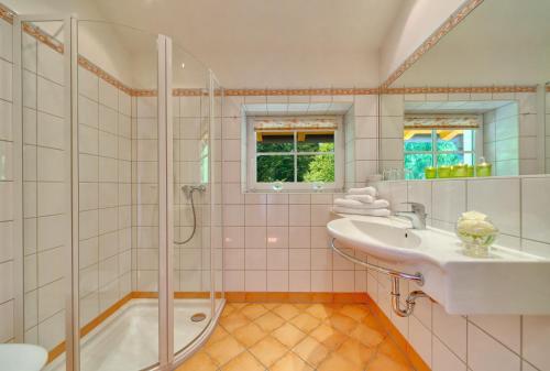 a bathroom with a sink and a shower at Hotel Fischerwirt Natur WaldSPA in Faistenau