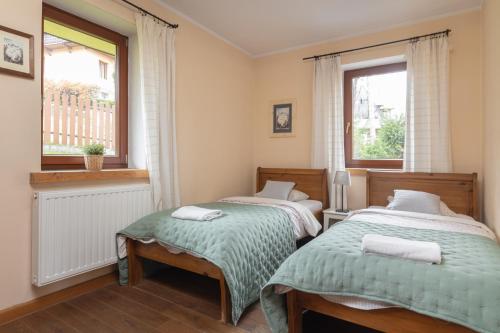 ザコパネにあるApartamenty Domino - Zakopaneのベッドルーム1室(ベッド2台、窓付)