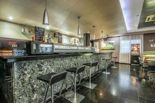 a bar in a restaurant with stools at Hotel Ruta Romana in Sagunto
