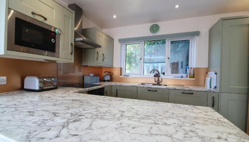 a large kitchen with a marble counter top at Yr Hen Berllan in the Beautiful Rowen in Conwy