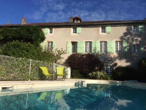 a house with a swimming pool in front of a building at ensemble de deux chambres pour famille in Planioles