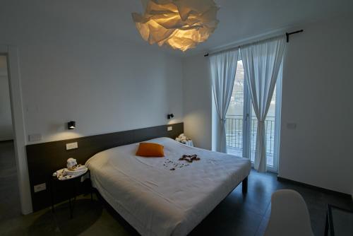 - une chambre avec un grand lit et un lustre dans l'établissement Appartamento Batell, à Lezzeno