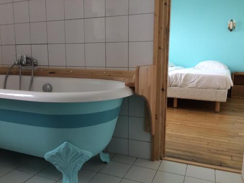 a bathroom with a bath tub and a bed at Hotel Particulier Richelieu in Calais