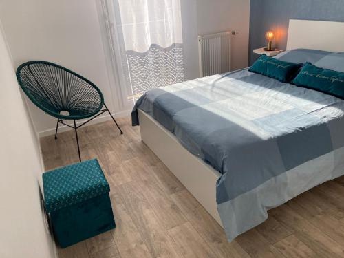 a bedroom with a large bed and a chair at F3 standing in Les Ulis