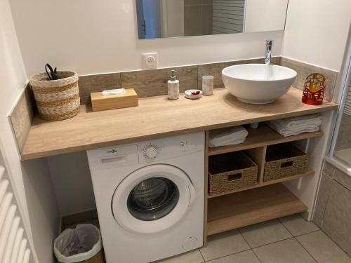 a bathroom with a sink and a washing machine at F3 standing in Les Ulis