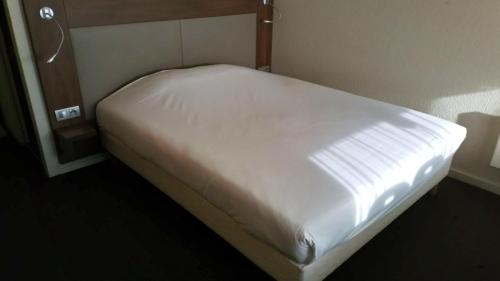 A bed or beds in a room at Kyriad Direct Metz Nord – Woippy