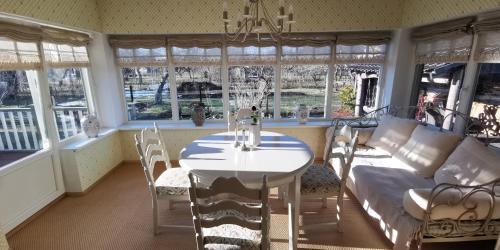 a dining room with a table and chairs and windows at Emma Villa in Pärnu