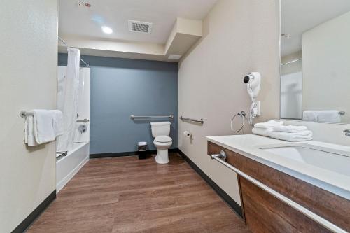 a bathroom with a toilet and a sink and a tub at Extended Stay America Suites - San Francisco - San Mateo - SFO in San Mateo