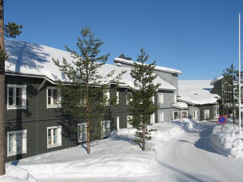a large building with trees in the snow at Hotel Ylläsrinne in Ylläsjärvi