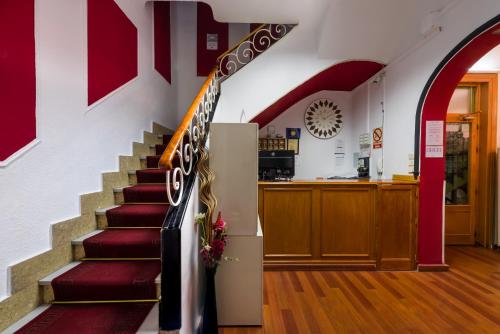 uma escada numa loja com paredes vermelhas e brancas em Hostal Valencia Madrid em Madri