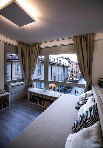 a bedroom with a large window and a bed with pillows at Downtown Como-Luxury Suites in Como