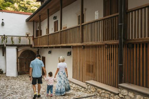 a man and a woman and a child walking through a building at Rooms & Apartments Podsreda Castle in Podsreda