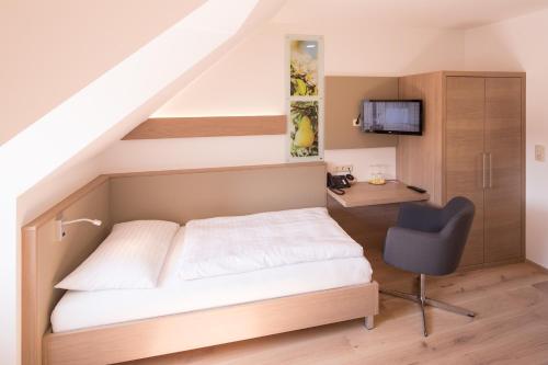 a bedroom with a bed and a desk and a chair at Hotel Stadt Melk in Melk