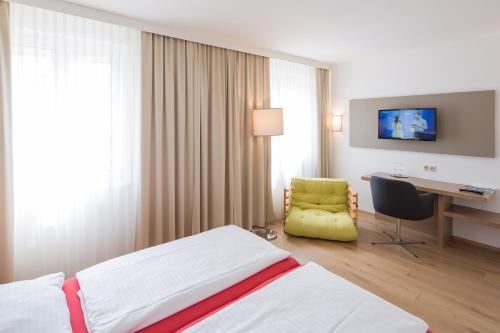 a hotel room with a bed and a desk at Hotel Stadt Melk in Melk