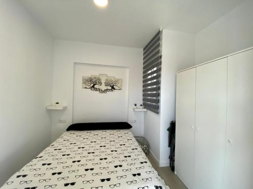 1 dormitorio con paredes blancas y 1 cama en una habitación en Casa Carmen Ático Primera linea de playa en Málaga