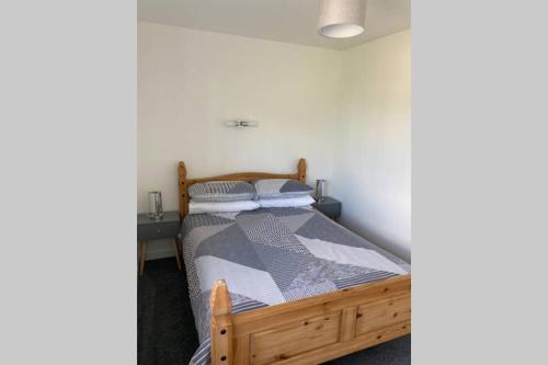 ein Schlafzimmer mit einem Holzbett in einem Zimmer in der Unterkunft The Gallafield, Self Catering Bungalow , Stornoway in Stornoway
