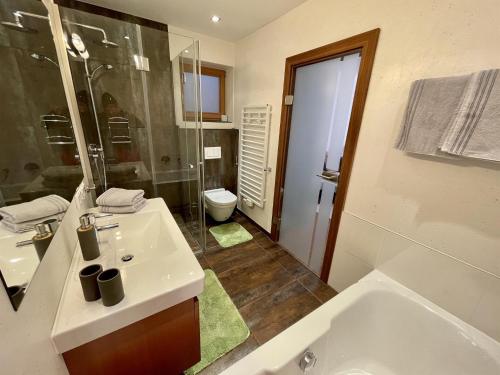 a bathroom with a sink and a tub and a toilet at Mona Apartment in Going