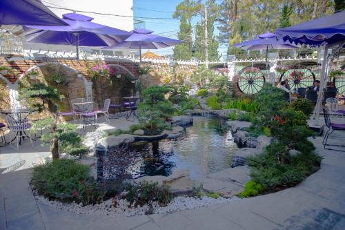 a garden with a pond and chairs and umbrellas at Win Villa Coffee in Da Lat