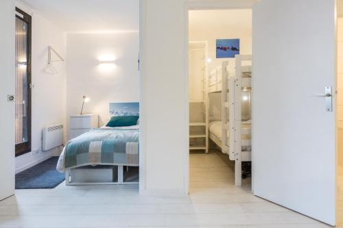 een witte slaapkamer met een bed en een raam bij Apartment Mont du Soleil in Chamonix-Mont-Blanc