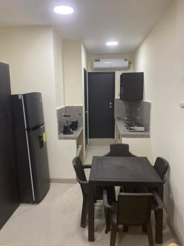 a dining room with a table and a refrigerator at WHITE HOUSE in Guayaquil