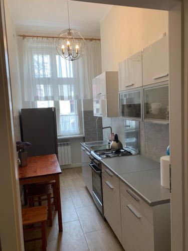 a kitchen with white cabinets and a stove top oven at Apartament BR0DNICA UL DUŻY RYNEK 31 , 2 in Brodnica