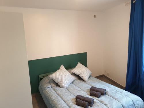ein Schlafzimmer mit einem Bett mit zwei Kissen darauf in der Unterkunft Résidence Emilie in Perpignan