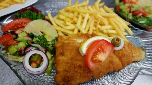 a plate of food with fish and french fries at Willa Kapitańska i Willa Marynarska in Łeba