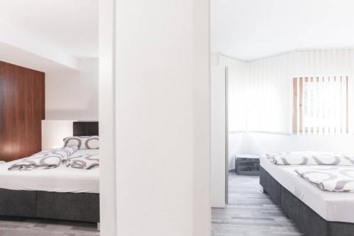 2 camas en una habitación con paredes blancas en Apart Hackl en Sautens