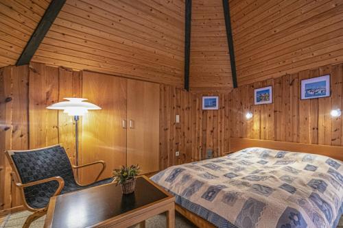 a bedroom with a bed and a table and a chair at Club Tihany Bungalows in Tihany