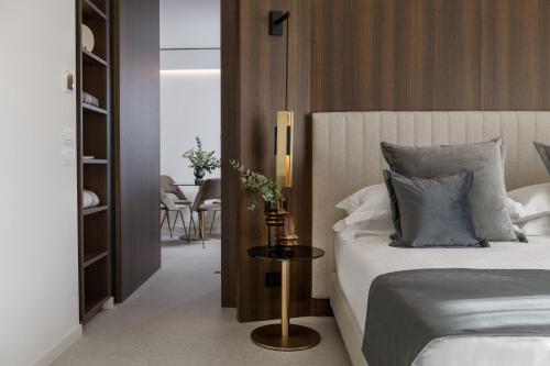 a bedroom with a bed and a table with a lamp at We Me Suite Hotel in Riccione