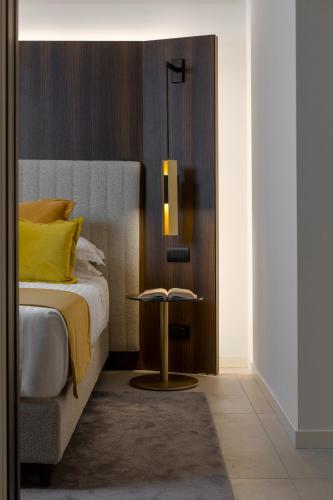 a bedroom with a bed and a side table at We Me Suite Hotel in Riccione