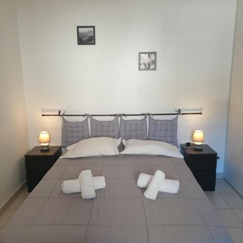 - une chambre avec un grand lit et 2 oreillers blancs dans l'établissement Appart RDC ALZETU CLIMATISE - 2 MIN PLAGE - PISCINE, à Lecci