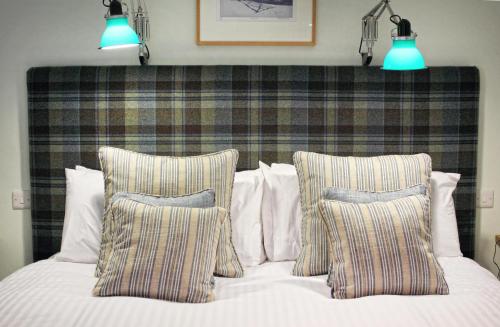a bed with two pillows and two lights above it at The Fountaine Inn in Linton