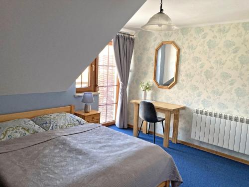 Lipowiec的住宿－Brzozowy Dworek - Winnica Lipowiec，一间卧室配有一张床、一张书桌和一个窗户。