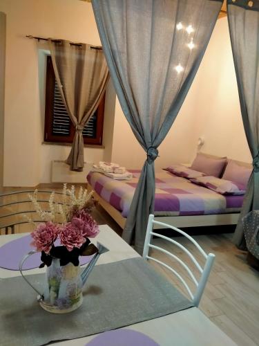 a room with two beds and a table with a vase of flowers at Il Loft nel Borgo Sospeso "con vista panoramica" in Vitorchiano