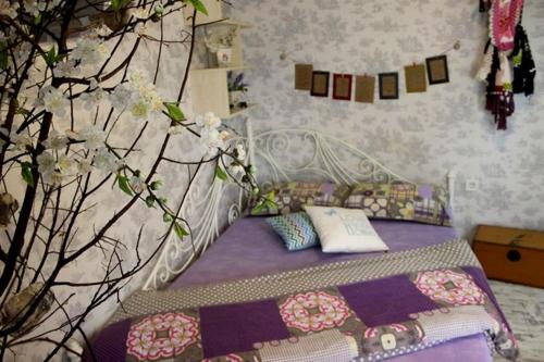 a bedroom with a bed with a blanket and a tree at AKİDE BUTİK PANSİYON in Mudanya