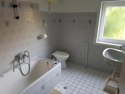 a bathroom with a tub and a toilet and a sink at Villa-Negra Retro Panzió in Balatonföldvár