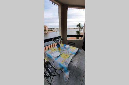 un tavolo sul balcone con vista sull'oceano di bel Appartement vue sur le lac marin avec WIFI et piscine a Le Barcarès