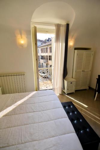 a bedroom with a large white bed and a balcony at La Terrazza Vercelli Bed & Charme in Vercelli
