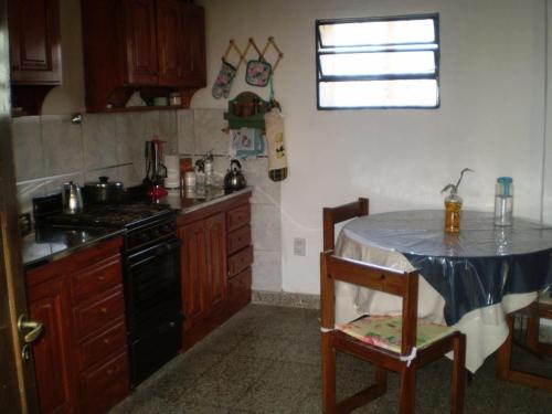 a kitchen with a table and a stove and a window at Hostel Marino Rosario in Rosario