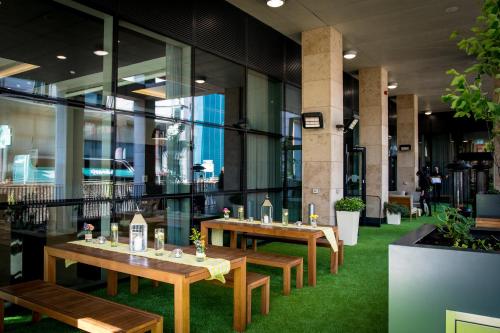 a restaurant with wooden tables and green grass at Holiday Inn Manchester - City Centre, an IHG Hotel in Manchester