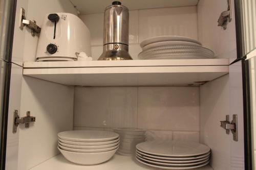 a kitchen with white plates and dishes on a shelf at INSIDEHOME Apartments - Ático del Val in Valladolid