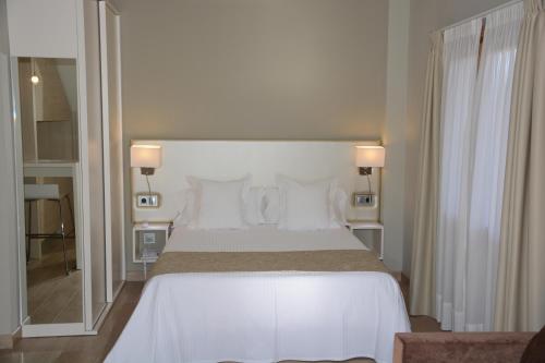 a bedroom with a large bed with white sheets and pillows at Tinas de Pechon in Pechón