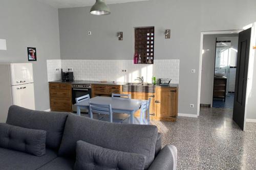 un salon et une cuisine avec un canapé et une table dans l'établissement Appartement indépendant dans maison de village, à Saint-André-de-Sangonis