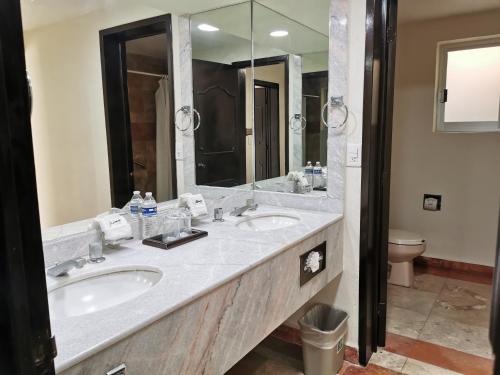La salle de bains est pourvue de 2 lavabos et d'un grand miroir. dans l'établissement Mirador Acapulco, à Acapulco