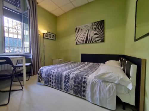 - une chambre avec un lit, un bureau et une fenêtre dans l'établissement Monolocale Caraglio, à Turin