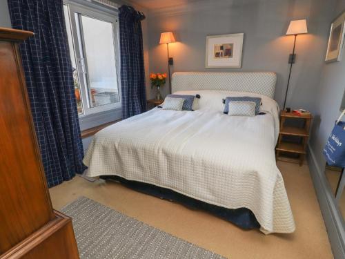 a bedroom with a white bed with blue pillows at Lion House in Newton Abbot