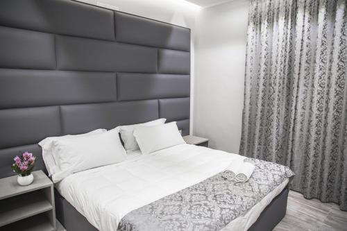 a bedroom with a large bed with a black headboard at Correnti Boutique Hotel in Sanremo