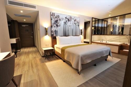 a hotel room with a bed and a bath tub at Limak Skopje Luxury Hotel in Skopje